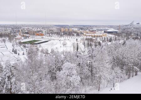 Lahti, Finnland 14. Februar 2021. Foto von der Drohne. Blick auf die Stadt, schneebedeckte Wohngebäude und Straßen, teilweise bewaldete Gegend. Der Tag ist bewölkt, Winter. Hochwertige Fotos Stockfoto