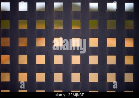 Detail eines schwarzen Blechzauns mit quadratischen Löchern Stockfoto