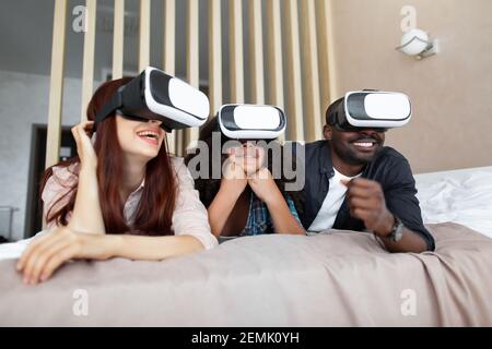 Es ist unglaublich. Aufgeregt glücklich multiethnische Familie mit Teenager-Tochter, Film oder Cartoons mit 3D Virtual-Reality-Brille zum ersten Mal Stockfoto