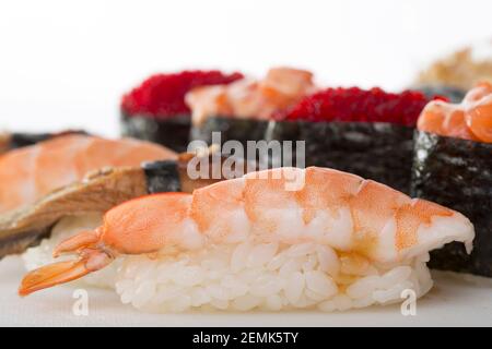 EBI Nigiri Sushi Nahaufnahme mit Gunkans und anderen Sushi. Makro. Auf einem Tisch als Hintergrund. Stockfoto