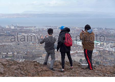 Edinburgh, Schottland, Großbritannien. Februar 2021, 25th. Menschen genießen die Sonne und im Freien im Holyrood Park. Blick nach Norden über die vierte Mündung vom Gipfel des Arthurs Seat. Kredit: Craig Brown/Alamy Live Nachrichten Stockfoto