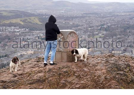 Edinburgh, Schottland, Großbritannien. Februar 2021, 25th. Menschen genießen die Sonne und im Freien im Holyrood Park. Blick auf den Südwesten der Stadt mit Blick auf die Pentland Hills vom Gipfel des Arthurs Seat. Kredit: Craig Brown/Alamy Live Nachrichten Stockfoto