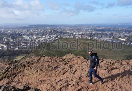 Edinburgh, Schottland, Großbritannien. Februar 2021, 25th. Menschen genießen die Sonne und im Freien im Holyrood Park. Vom Gipfel des Arthurs Sitz mit Blick auf Edinburgh Castle. Kredit: Craig Brown/Alamy Live Nachrichten Stockfoto