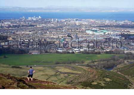 Edinburgh, Schottland, Großbritannien. Februar 2021, 25th. Menschen genießen die Sonne und im Freien im Holyrood Park. Von den Hängen des Arthurs Sitz mit Blick über die Stadt und Forth Estuary Blick nach Norden in Richtung Fife. Kredit: Craig Brown/Alamy Live Nachrichten Stockfoto