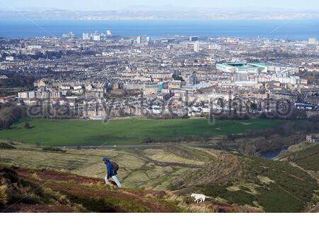 Edinburgh, Schottland, Großbritannien. Februar 2021, 25th. Menschen genießen die Sonne und im Freien im Holyrood Park. Von den Hängen des Arthurs Sitz mit Blick über die Stadt und Forth Estuary Blick nach Norden in Richtung Fife. Kredit: Craig Brown/Alamy Live Nachrichten Stockfoto