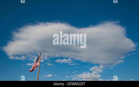 Amerikanische Flagge auf dem blauen und bewölkten Himmel Stockfoto