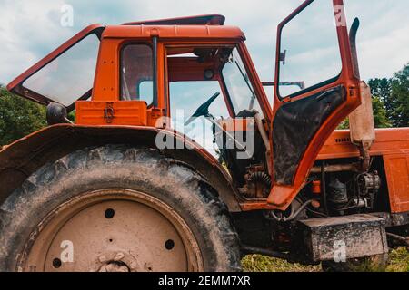 Alte rote Traktor auf dem Feld während der Heuernte Saison, Pressen Heu auf Ballen, Futter harvesting,2021 Stockfoto