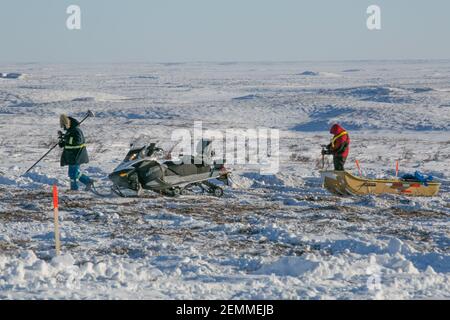 Vermesser bei der Arbeit an der gefrorenen Tundra während des Winterbaus des Inuvik-Tuktoyaktuk Highway, Northwest Territories, Kanadas Arktis. Stockfoto