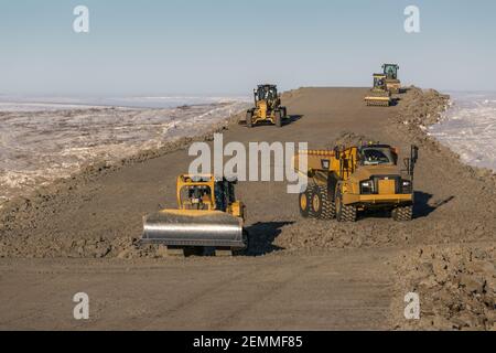 Caterpillar Schwerlastwagen bauen den Kies Inuvik-Tuktoyaktuk Highway während der Winterbauarbeiten, Nordwest-Territorien, Kanadas Arktis. Stockfoto