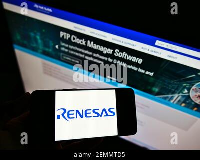 Person hält Smartphone mit Logo der japanischen Firma Renesas Electronics Corporation auf dem Bildschirm vor der Website. Konzentrieren Sie sich auf die Telefonanzeige. Stockfoto