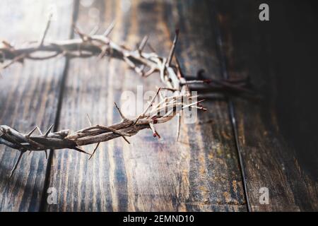 Christliche Dornenkrone wie Christus trug mit Bluttropfen über einem rustikalen Holzhintergrund oder Tisch. Selektiver Fokus mit unscharfem Hintergrund. Stockfoto