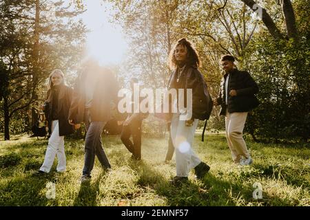 Männliche und weibliche Freunde hängen im Park auf sonnig Tag Stockfoto