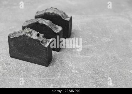 Seifenstücke handgefertigt aus natürlicher Holzkohle auf grauem Hintergrund Stockfoto