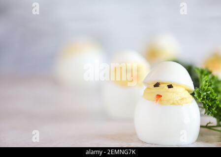 Deviled Eier für Ostern geschmückt als niedliche kleine Küken schlüpfen aus Eiern mit Karottenschnabel und Algen Augen. Extrem geringe Schärfentiefe mit Unschärfe Stockfoto