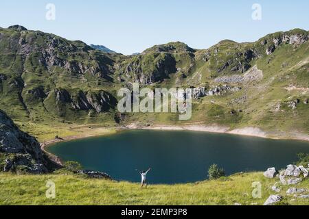 Sorgloser Mann mit erhobener Hand auf einem See - Lagos de Saliencia- Asturien- Spanien Stockfoto