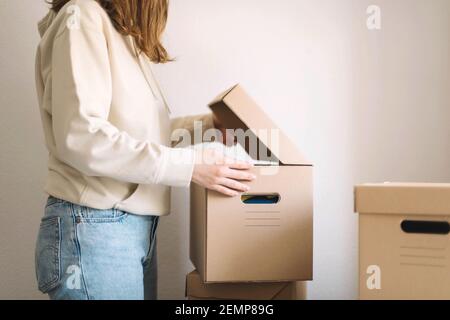 Junge Frau bewegt Pappkartons in neue Heimat Stockfoto