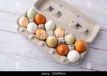 Frische Eier von Freilandhühnern auf einem kleinen Bauernhof, schöne bunte Eier von verschiedenen Hühnerrassen Stockfoto