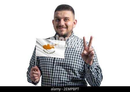 Weißer Kerl hält eine Flagge von Zypern und zeigt zwei Finger isoliert auf einem weißen Hintergrund. Stockfoto