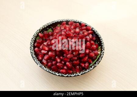 Geschälte Granatapfelkerne in einem gemusterten Teller Stockfoto