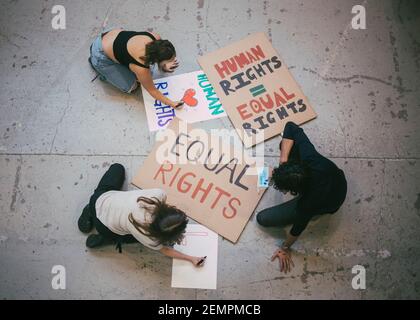 Direkt über der männlichen und weiblichen Aktivistin, die Plakate vorbereitet Soziale Probleme während der Pandemie Stockfoto