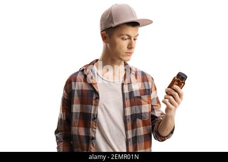 Männliche Teenager Blick auf eine Flasche Pillen isoliert auf Weißer Hintergrund Stockfoto