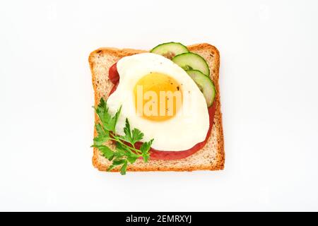 Toast mit Tomaten Ketchup, Gurke und Spiegelei isoliert auf weißem Hintergrund, Draufsicht. Stockfoto