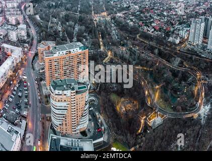 Luftaufnahme Panorama des Charkiw Stadtzentrum Park. Botanischer Garten Sarzhyn Yar und mehrstöckige moderne hohe Gebäude am Abend. Winterstadt mit stre Stockfoto