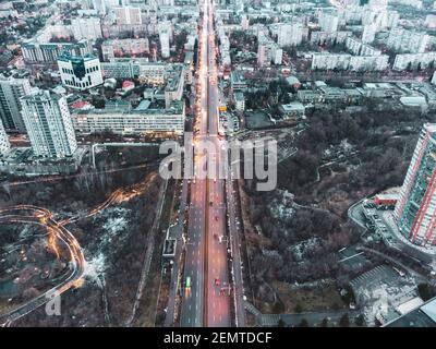 Luftaufnahme Kharkiv Stadtzentrum Nauky ave. Botanischer Garten Sarzhyn Yar und mehrstöckigen modernen Gebäuden am Abend. Graue Winterstadt mit roter Straße Stockfoto