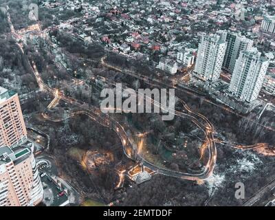Luftaufnahme Kharkiv Stadtzentrum Park. Botanischer Garten Sarzhyn Yar und mehrstöckige moderne hohe Gebäude am Abend. Graue Winterstadt mit Straßenlaterhe Stockfoto