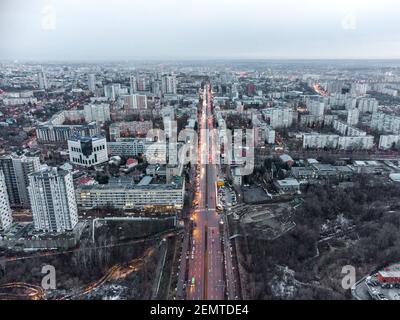Luftaufnahme Kharkiv Stadtzentrum Nauky Avenue. Botanischer Garten Sarzhyn Yar und mehrstöckige moderne hohe Gebäude am Abend. Graue Winterstadt mit Rot Stockfoto