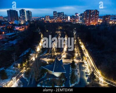 Luftaufnahme Kharkiv Stadtzentrum Erholungspark Sarzhyn Yar mit Nachtlicht und modernen Wohnviertel. Botanischer Garten Wasserquelle und Gasse Stockfoto