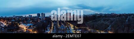 Aerial breiten Panoramablick Kharkiv Stadtzentrum beliebten Erholungspark Sarschyn Yar mit Lichtern und modernen Bezirk. Botanischer Garten Wasserquelle und ein Stockfoto