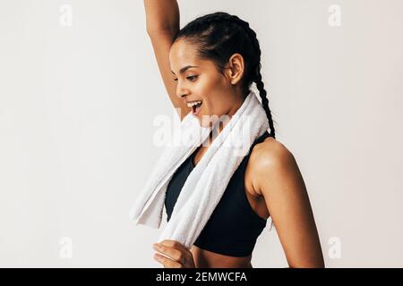 Seitenansicht einer glücklichen Mixed-Race-Frau mit einem weißen Handtuch um den Hals Stockfoto