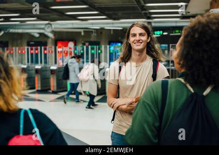 Junge Freundinnen und Freundinnen, die nachts in der U-Bahn reden Stockfoto