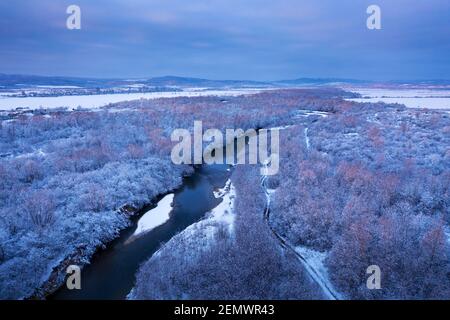 Flug durch majestätischen Fluss, gefrorenen Wald und frostigen Winterfeldern bei Sonnenaufgang. Landschaftsfotografie Stockfoto