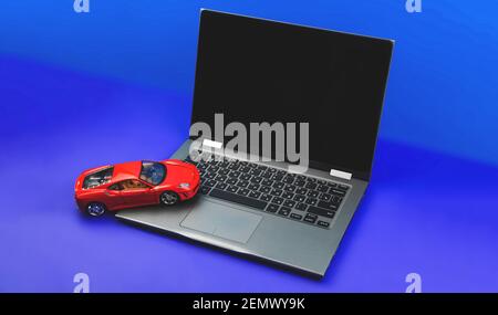 Charkov, Ukraine - 24. Februar 2021: Sportwagen Ferrari Modell, Arbeitsbereich mit Laptop, blauer Hintergrund, Platz für Ihren Text Stockfoto