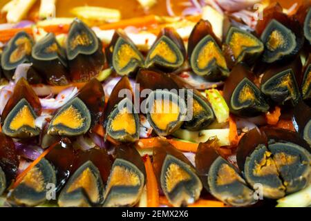 Street Food Markt in Asien. Eine Nahaufnahme, traditionelles Gericht aus in Scheiben geschnittenen eingelegten Hühnereiern. Stockfoto