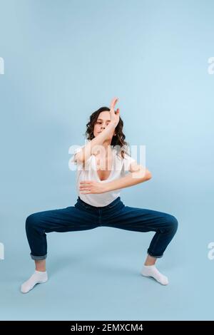 Hübsche zeitgenössische Tänzerin in fester Haltung, macht Bewegungen mit ihren Armen. Stockfoto