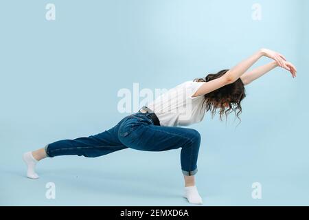 Expressive, zeitgenössische Tänzerin, die den Körper nach vorne auslenkt und wellenartige Bewegungen macht. Stockfoto