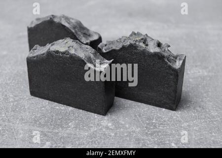 Seifenstücke handgefertigt aus natürlicher Holzkohle auf grauem Hintergrund Stockfoto