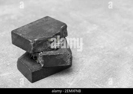 Seifenstücke handgefertigt aus natürlicher Holzkohle auf grauem Hintergrund Stockfoto