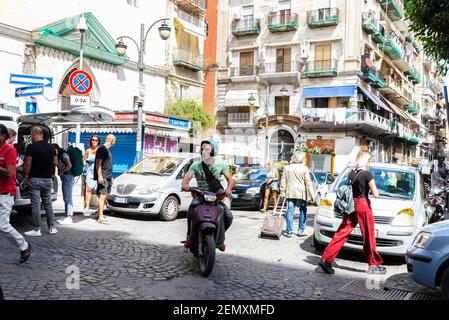 Neapel, Italien - 9. September 2019: Straße von alten Gebäuden mit einem Mann auf einem Motorrad in der Altstadt von Neapel, Italien Stockfoto