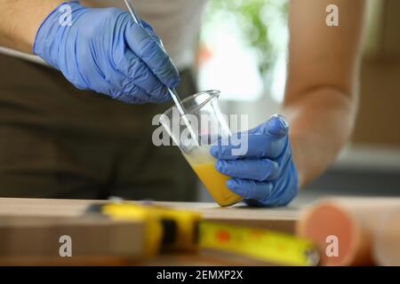 Mann, der Flüssigkeit im Testmischer mischt Stockfoto