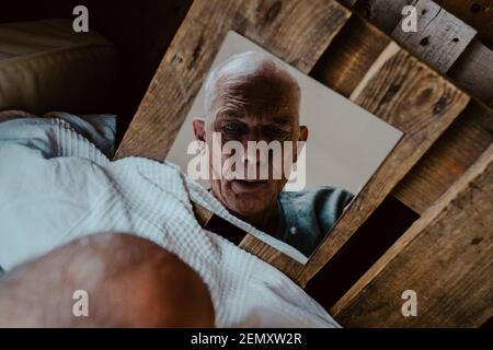 Direkt über der Aufnahme eines älteren Mannes, der im Spiegel ansah Zu Hause Stockfoto