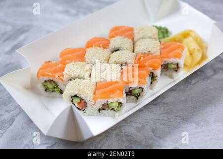 Takeaway-Box mit Sushi-Rollen auf Steintisch. Sushi-to-go-Konzept. Stockfoto