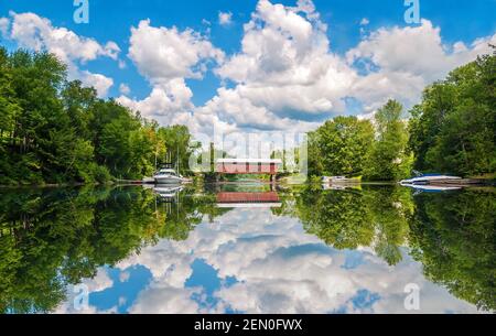 Eine überdachte Brücke und wunderschöne Spiegelungen an der Fitch Bay am Lake Memphremagog in Quebec, Kanada. Stockfoto