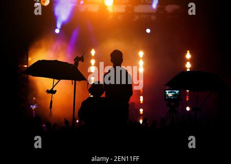 Crew-Team arbeitet an der Einstellung und Vorbereitung der Produktion für Show-Event oder Musikkonzert. Schwarze Silhouetten. Stockfoto