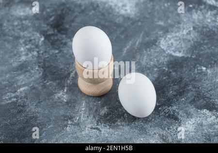Nahaufnahme von Eierbecher und Eier auf grau Hintergrund Stockfoto