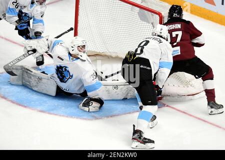 Riga, Lettland. Februar 2021, 25th. Dinamo Minsks Torwart Alexei Kolosov (L) verfehlt beim Eishockeyspiel der Kontinental Hockey League (KHL) 2020-2021 zwischen Dinamo Riga und Dinamo Minsk in Riga, Lettland, 25. Februar 2021 ein Tor. Kredit: Edijs Palens/Xinhua/Alamy Live Nachrichten Stockfoto