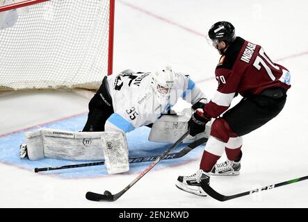 Riga, Lettland. Februar 2021, 25th. Dinamo Minsks Torhüter Alexei Kolosov (L) versucht beim Eishockey-Spiel der Kontinental Hockey League (KHL) 2020-2021 zwischen Dinamo Riga und Dinamo Minsk in Riga, Lettland, am 25. Februar 2021, einen Spar zu machen. Kredit: Edijs Palens/Xinhua/Alamy Live Nachrichten Stockfoto